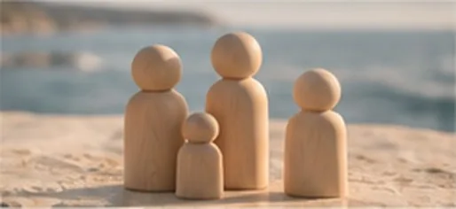 Figuras de madera que representan una familia, sobre la arena